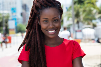 Impressionante donna africana con dreadlocks all'aperto in città in estate