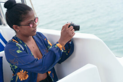 African Woman Using Camera In A Boat